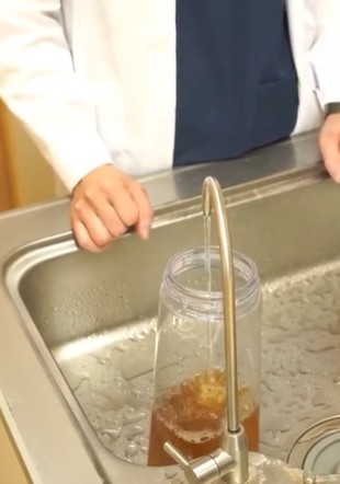 浄水器の蛇口から容器にお水を注いでいるところ